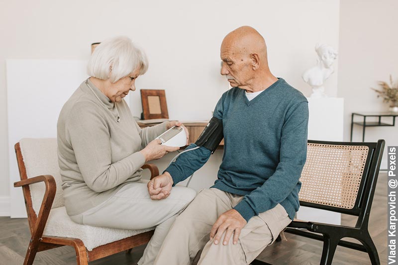 A close-up image of a person's arm with a blood pressure cuff wrapped around it in a calm home environment, symbolising the importance of regular at-home blood pressure monitoring