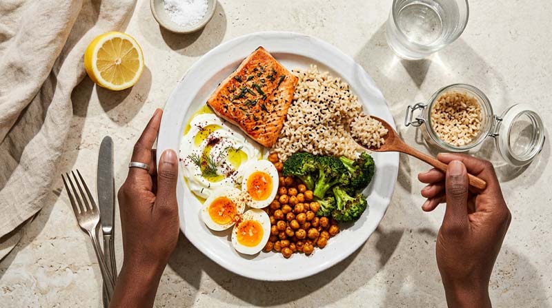 An overhead view of a balanced meal shows a small adjustment to the carbohydrate portion, highlighting how food intake can be tuned without turning the meal into a restrictive diet.
